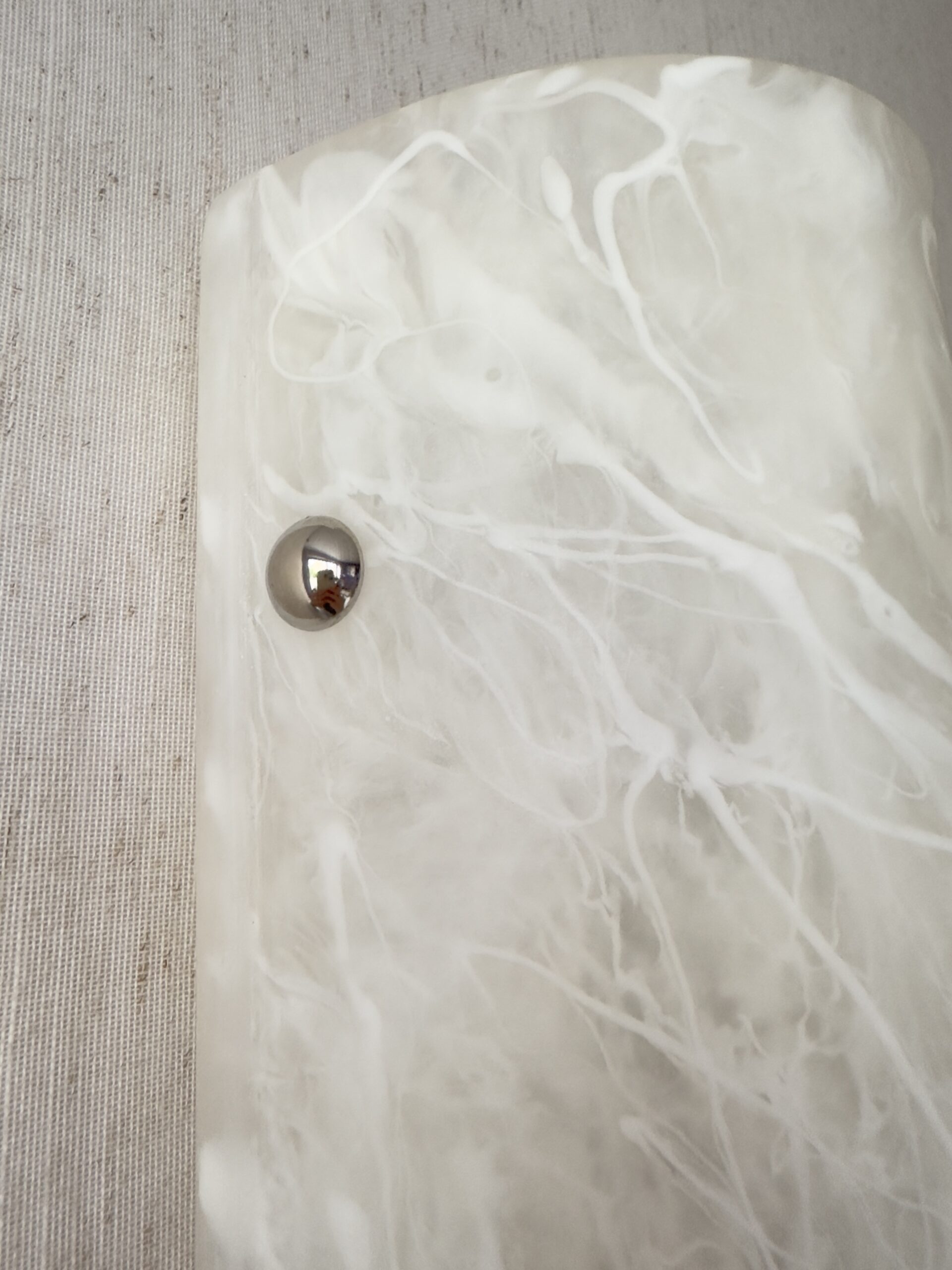 Wireless resin wall sconce with white quartz-inspired finish